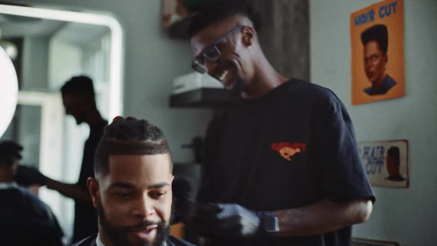 A barber brushing off a mans hair