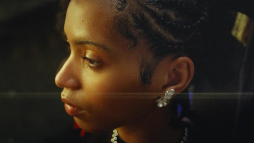 Person braiding hair with the help of a comb indoors