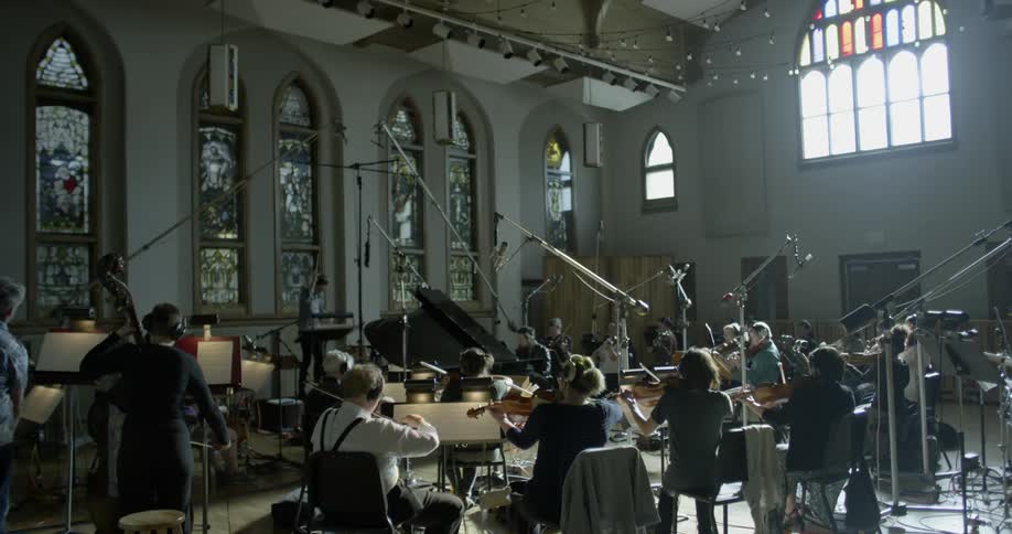 A man conducts a small orchestra