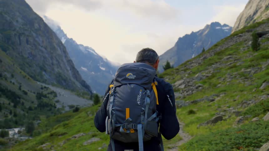 A hiker ascends the side of a mountain
