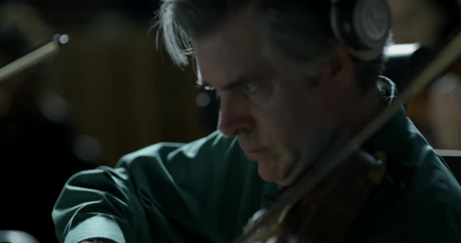 Man playing a violin in an orchestra