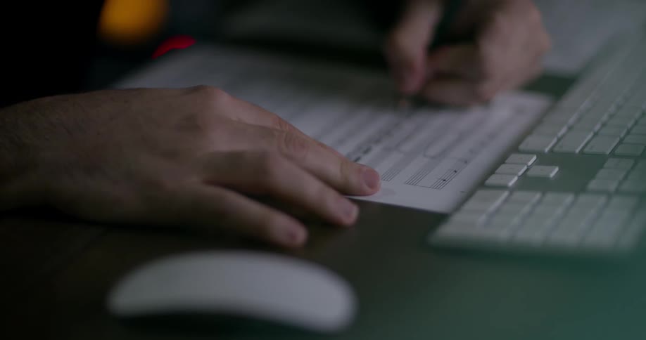 Person writing on sheet music