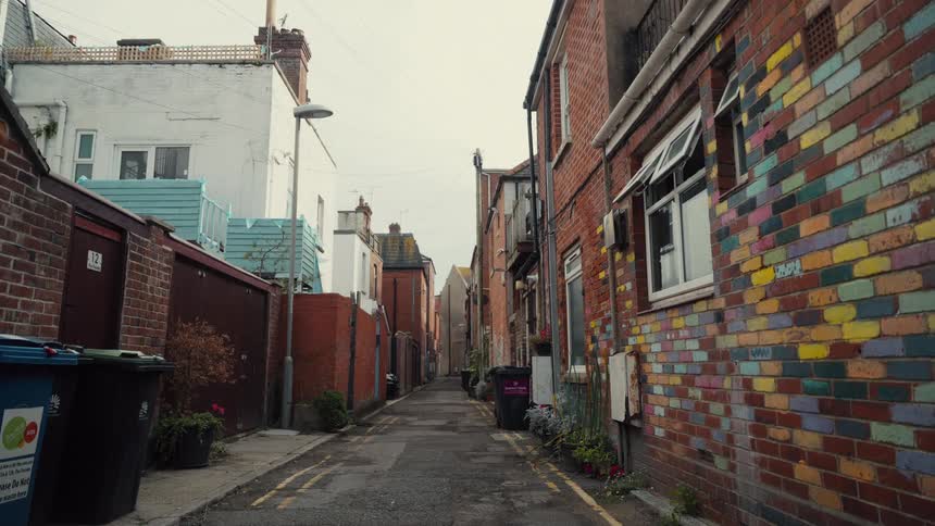 Alley with brick houses and buildings to both sides in an urban area outdoors during day time