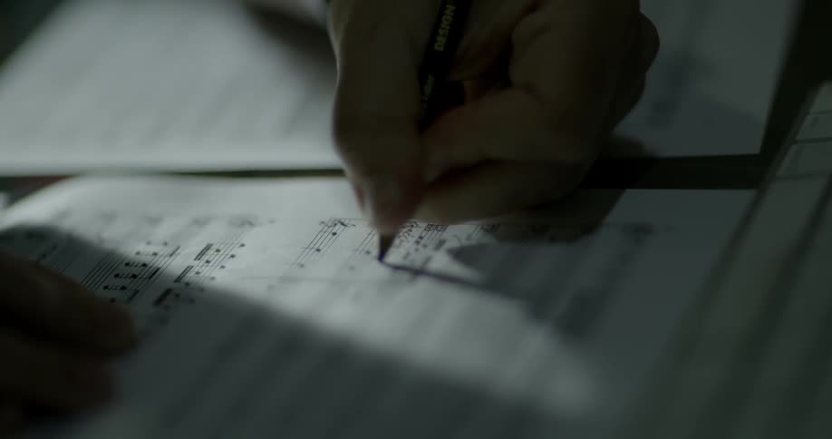 A person edits sheet music