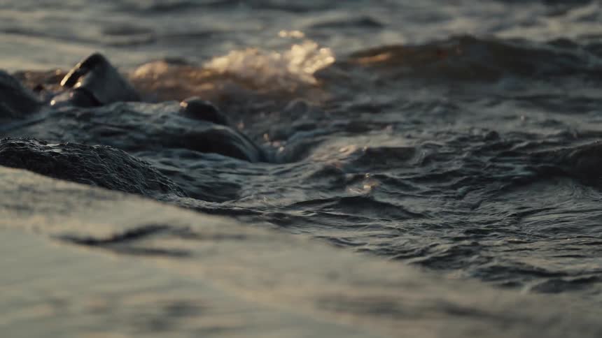 A close up of waves crashing on rocks