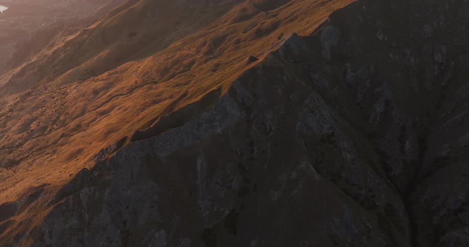 Sunlit mountain slope with a rocky cliff in shadow