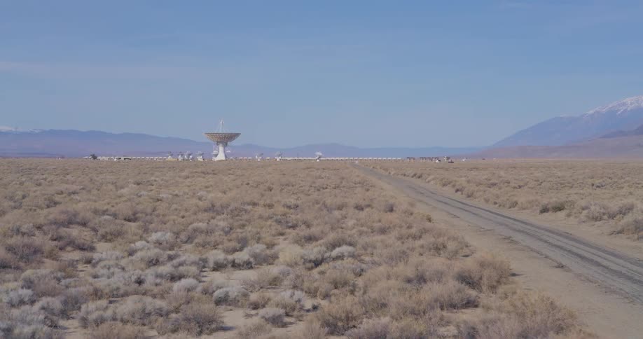 The satellite dish is in the distance of the desert