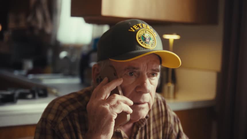 A man talking on a phone in a room