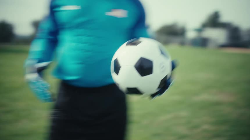 The man is tossing a soccer ball around