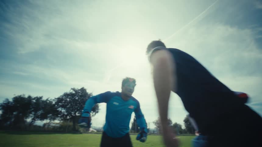 Two soccer players are jumping around on the field