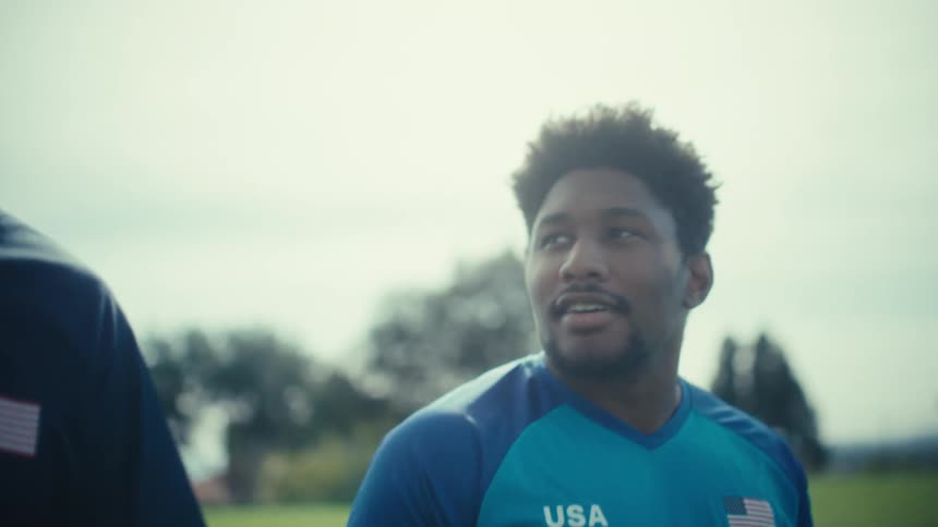 Two usa soccer players walking together on grassy field