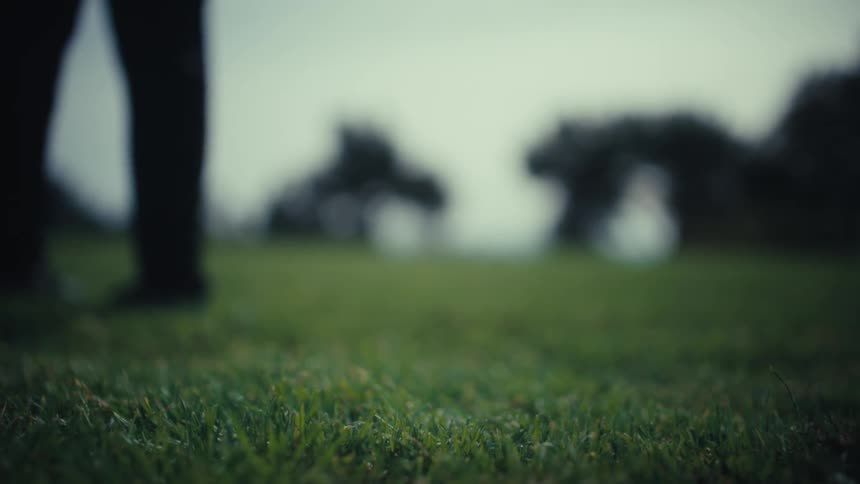 A football player kicks a soccer ball across the field at midday
