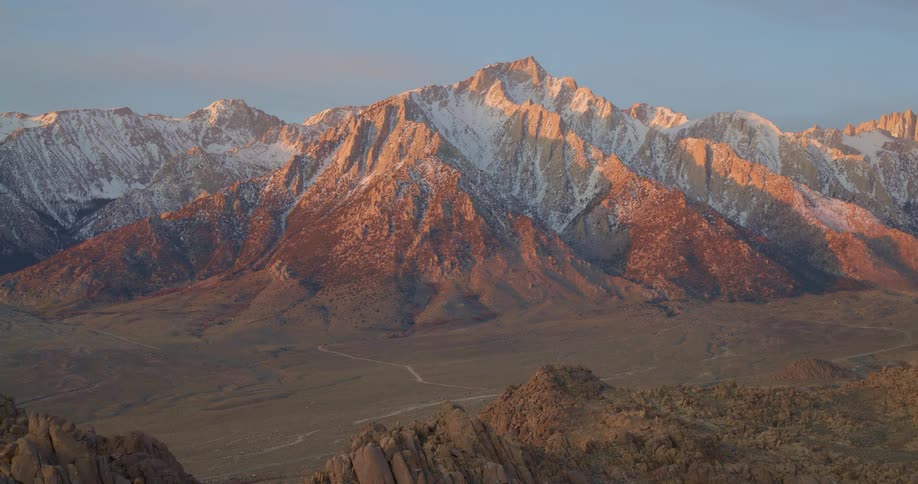 An aerial view of a mountain range with snow on it