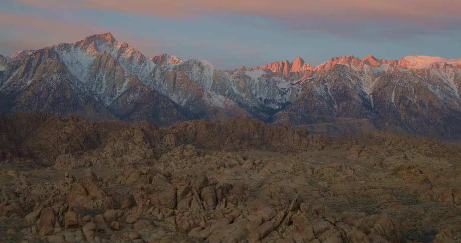 Rocks and badlands across the landscape with snow laced mountains in the distance