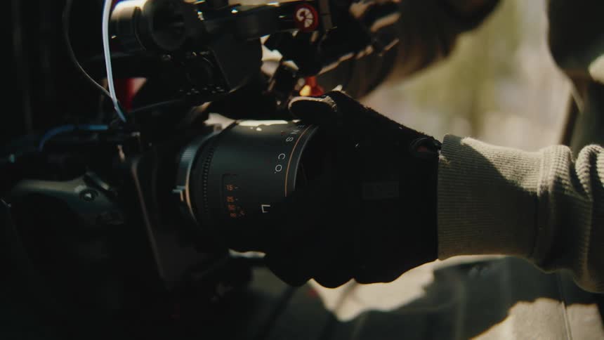 The man is attaching a lens to the camera