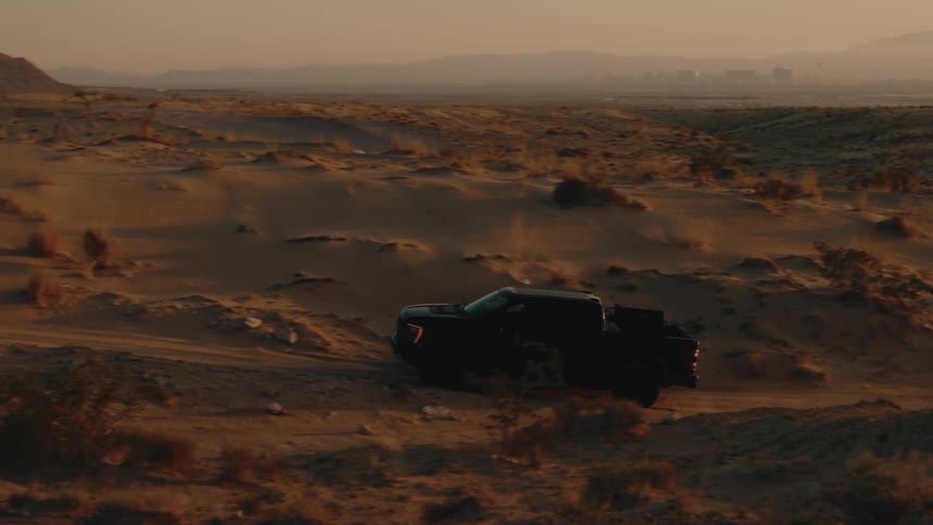 The truck drives over the sand in the desert