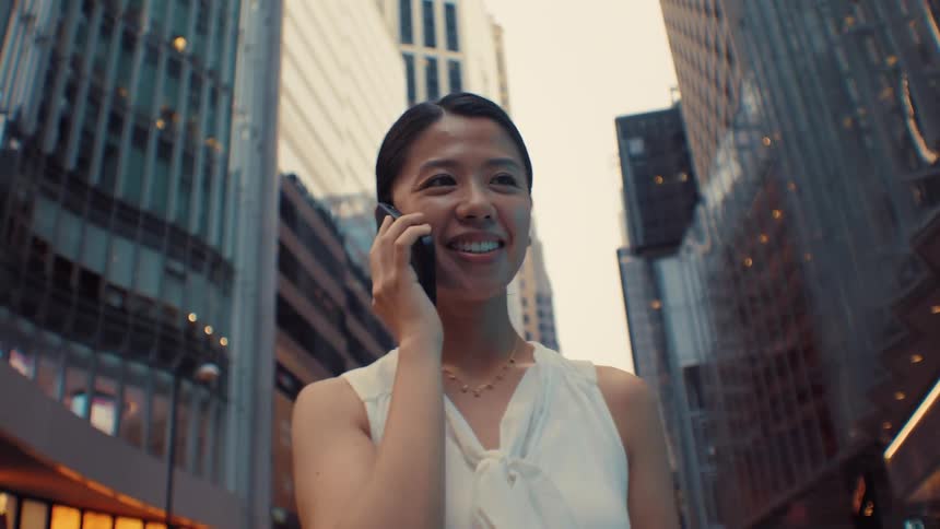 The woman is talking on her phone in the city
