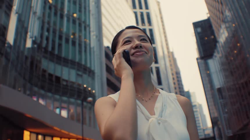 The woman is talking on her phone in the city