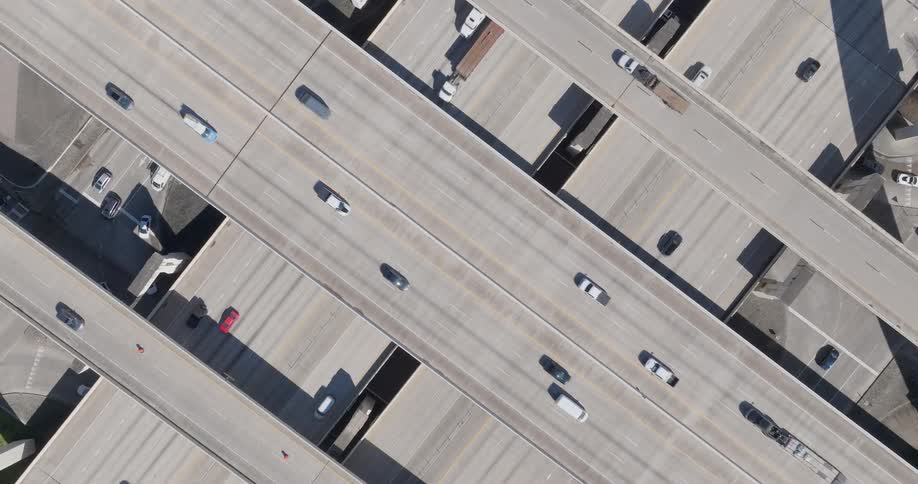 A multilevel overhead bridge with cars passing by on a sunny day in the city