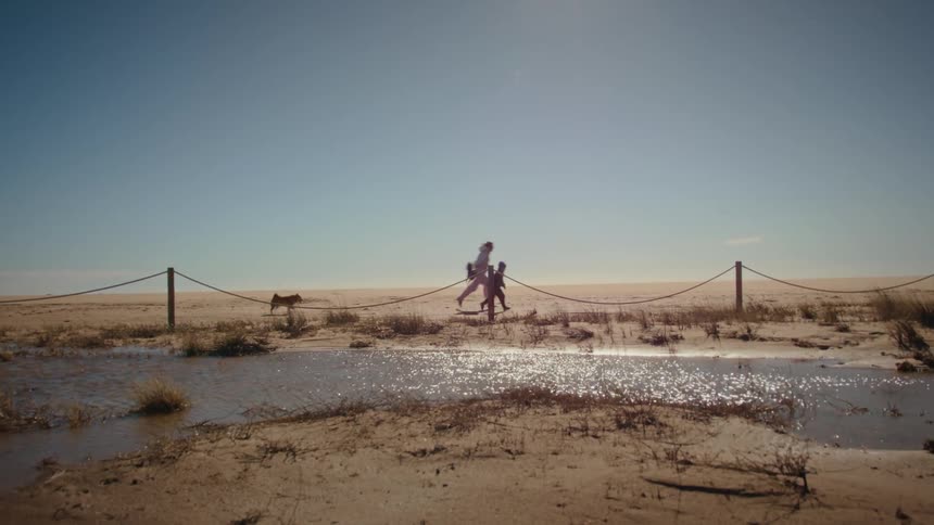 A mother and son running on the beach