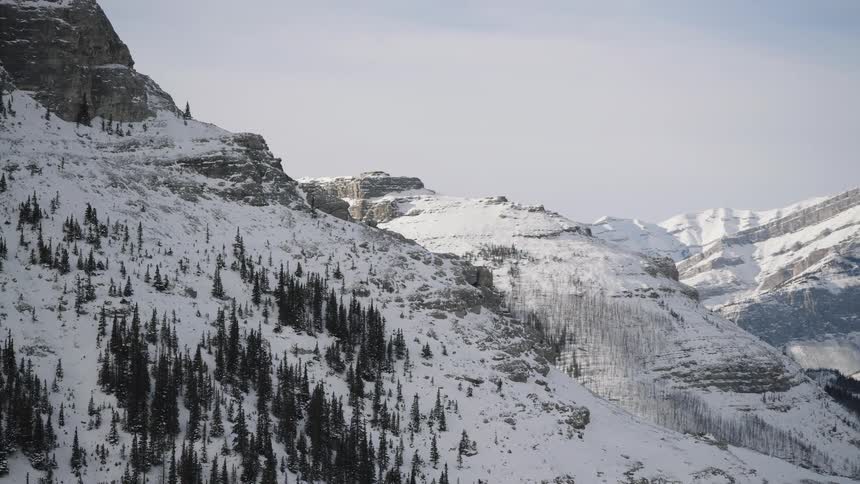 Snowcovered mountains with forested slopes and valleys in the background