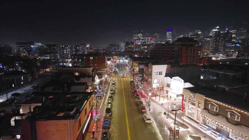 Aerial view of a decorated city street at night during wintertime