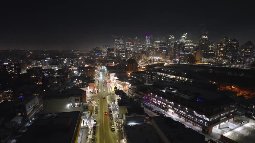 Lights on buildings glow on the metropolitan skyline as traffic moves on the city streets