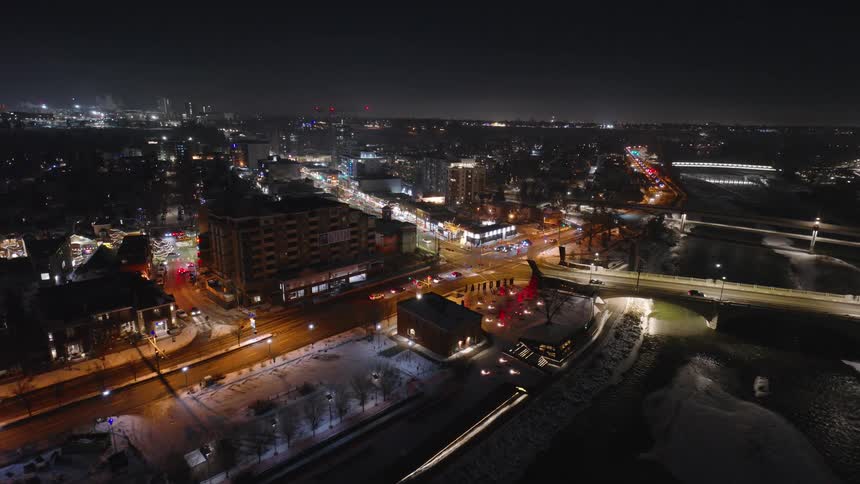 Aerial view of a city at night with streets traffic buildings and snow