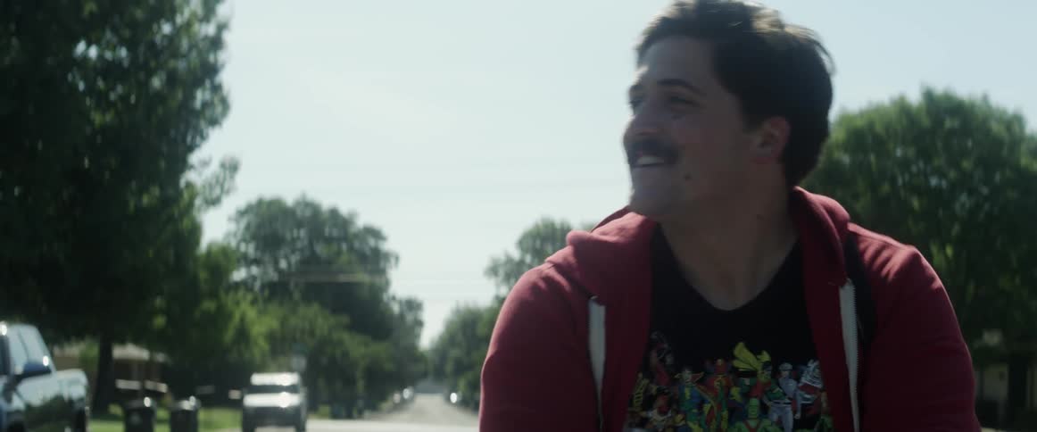 A man is riding his bicycle waving to people