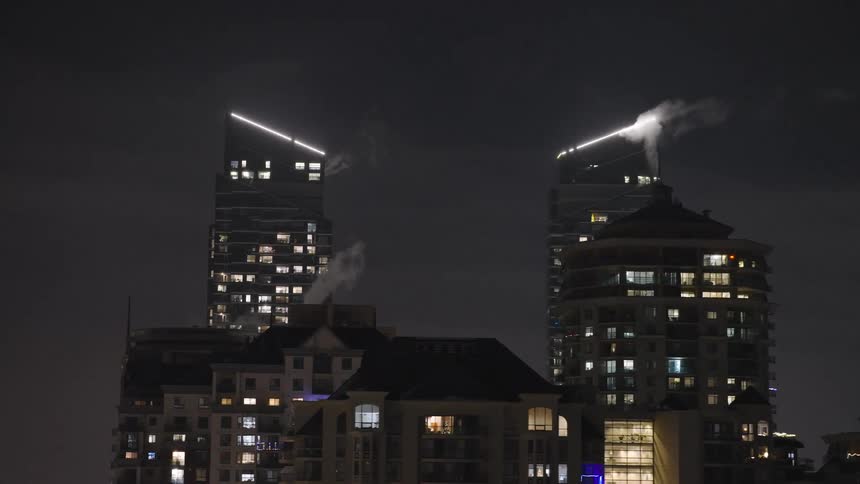 The tall buildings in the city are lit at night