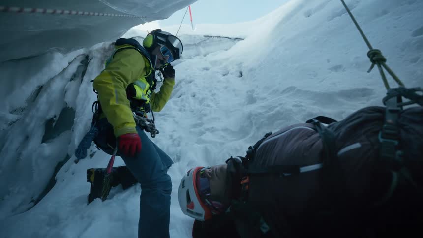 Rescuers communicate in a snow covered crevasse during a dangerous winter mountain operation