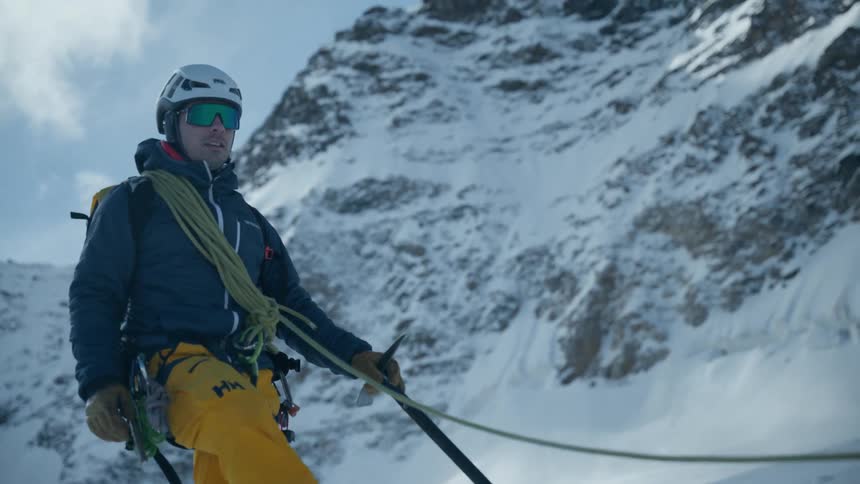 A man hiking up a snow covered mountain