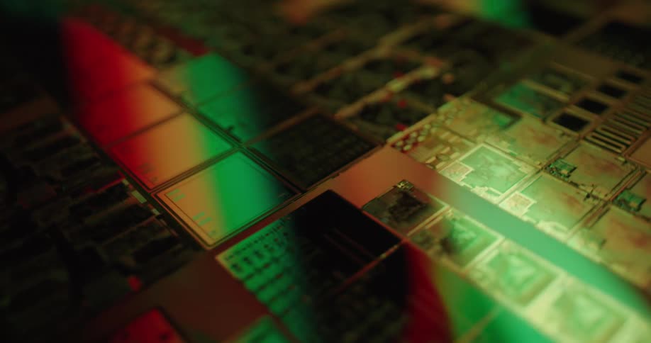 Dynamic colorful lighting in shades of neon blue red and green sweeps across the intricate geometric patterns of the microchip surfacethe camera glides over the reflective circuitry highlighting the complex internal architecture and metallic textur