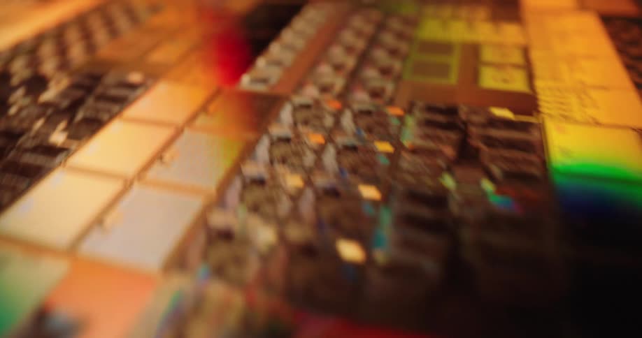 Microchip with electronic circuits and components illuminated by red green and golden lights
