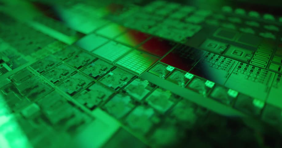 Microchip with modules and electronic traces under green lighting with a reddish stripe