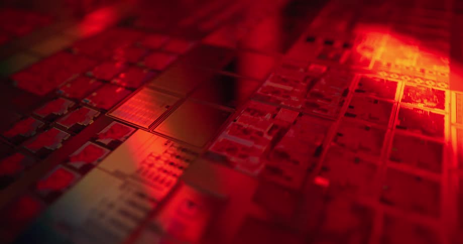 Microchip with electronic blocks and circuits illuminated by red light and colored reflections