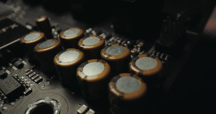 Cylindrical capacitors aligned on an electronic board with surrounding components