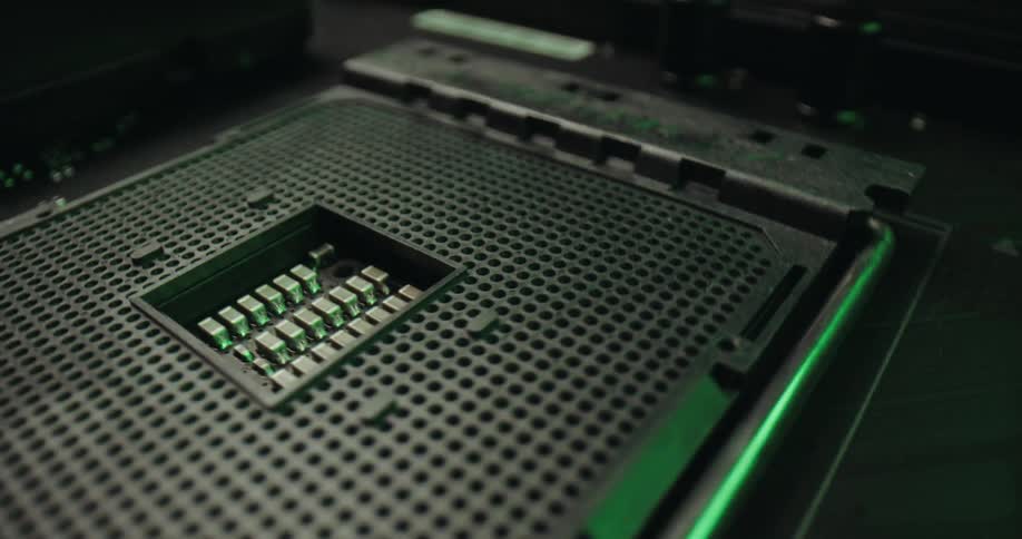 A closeup cinematic tracking shot of an empty cpu socket on a motherboardas the camera moves the scene is illuminated by shifting colored lights that transition from deep red to cool blue and vibrant green