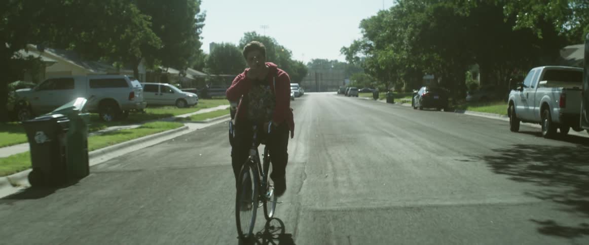 Man rides a bike in a neighborhood