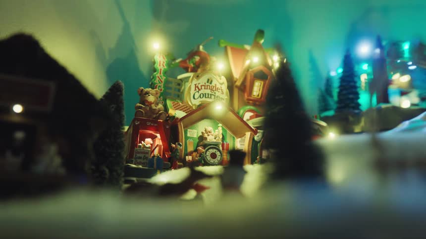 Santa sleigh figure moves through the air above figurines and other christmas decorations