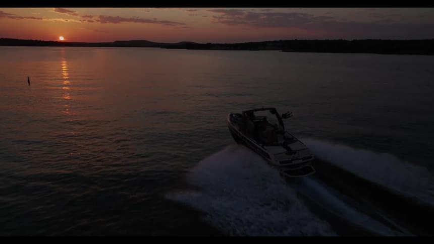 The speedboat travels across the lake at sunrise
