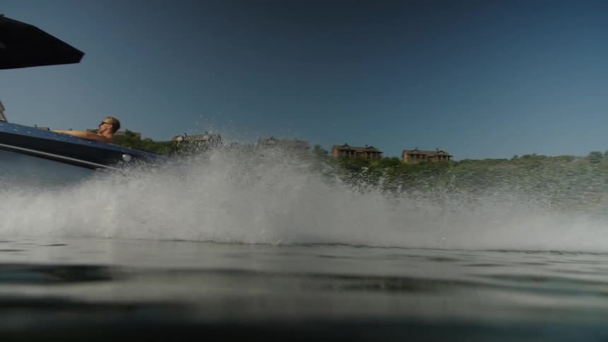 Water splashes as a boat sails near the coast
