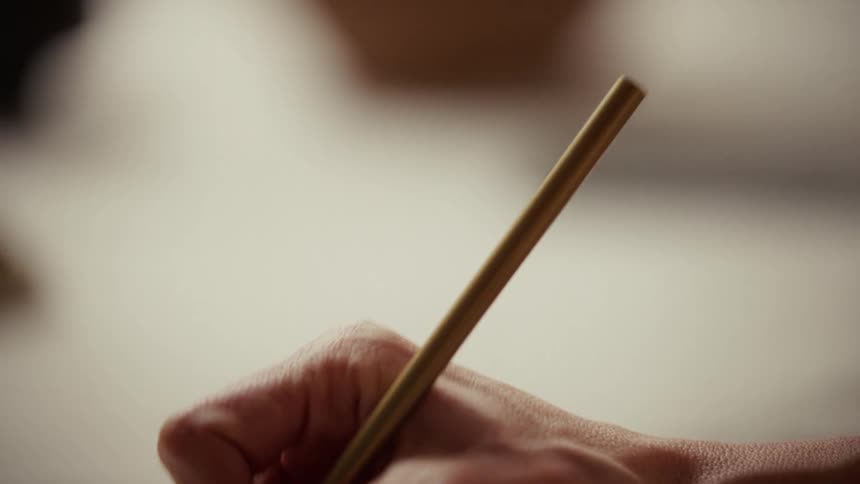 A person working with a small paint brush
