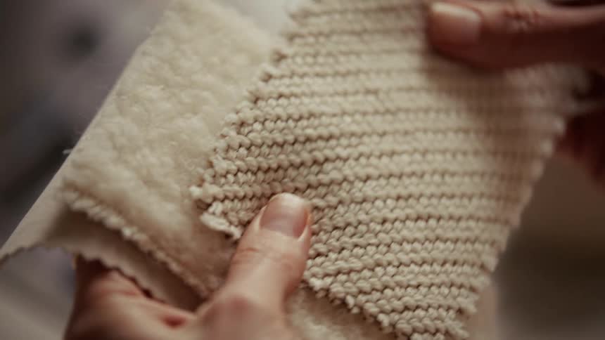 Woman examines textured samples in the same color that have different patterns