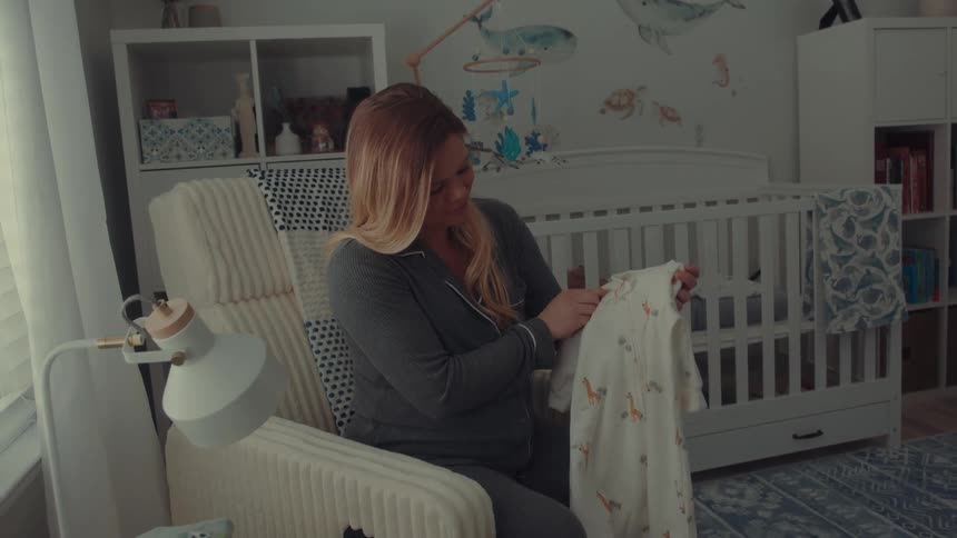 A woman folding clothes in a room