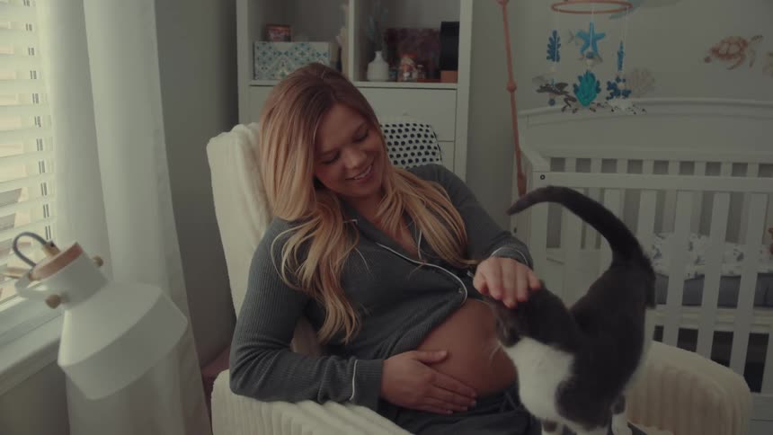 A woman sitting in a room with a cat