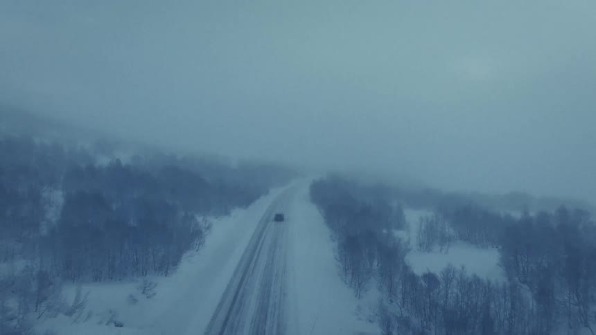 Snowcovered road with vehicle in motion