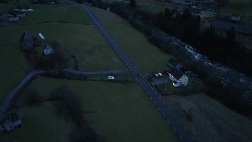 An aerial view of a car driving down a road