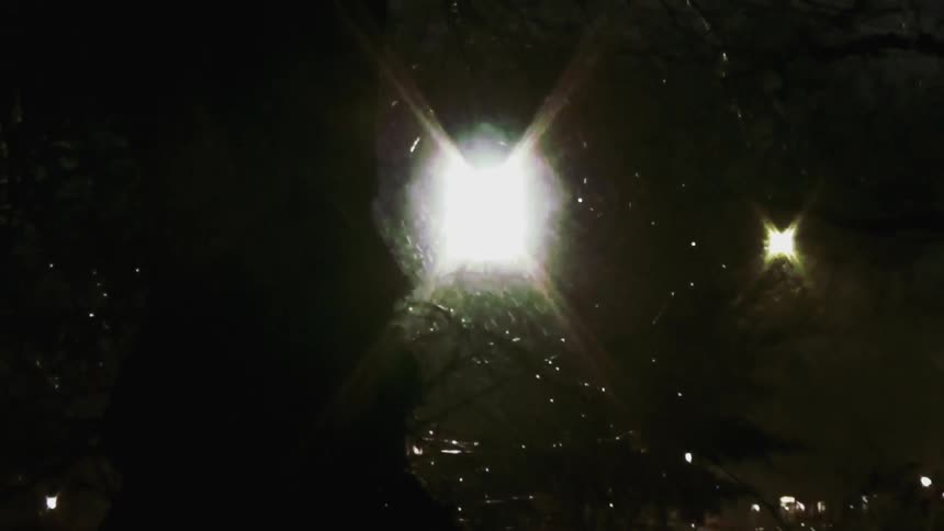 A street lamp illuminating the street on a rainy night