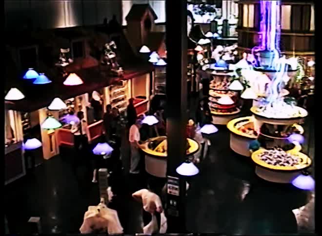 A large shopping mall with people walking around shopping